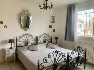 1 dormitorio con cama, lámpara de araña y ventana en Maison familiale avec jardin proche Rouen centre en Sotteville-lès-Rouen