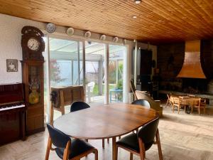 une salle à manger avec une table et une horloge grand-père dans l'établissement Maison familiale avec jardin proche Rouen centre, à Sotteville-lès-Rouen 18 autres photos