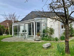 une maison en verre avec une table dans une cour dans l'établissement Maison familiale avec jardin proche Rouen centre et Armada, à Sotteville-lès-Rouen