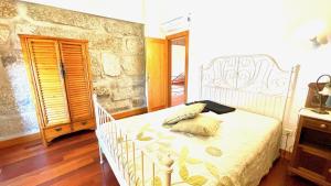 a bedroom with a white bed and a stone wall at Villa Amarela in Penafiel +35 photos