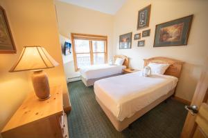 una camera d'albergo con due letti e una lampada di Hidden River Lodge 5979 a Keystone