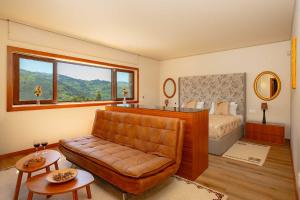 a bedroom with a couch and a bed with a window at Quinta de Cabanas Douro - By Unlock Hotels in Penha Longa