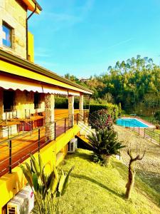 a yellow house with a swimming pool in a yard at Villa Amarela in Penafiel