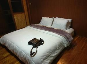 białe łóżko z czarnym łukiem w obiekcie Dirt Venture 2 Day 1 Night Trips w mieście Chiang Mai
