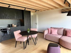uma sala de estar com um sofá, uma mesa e cadeiras em Durbuy Insolite - Natural Escape em Durbuy