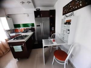małą kuchnię ze stołem i lodówką w obiekcie Apartament centru camera si living,4 persoane w Jassach