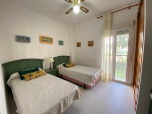 a bedroom with two beds and a window at Apartamento a pie de playa in Rota