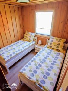 two beds in a room with a window at Domki przy Akacjowej in Rydzewo