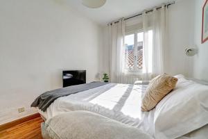 a white bedroom with a large bed and a window at Mesón Pamplona by Clabao in Pamplona +22 photos