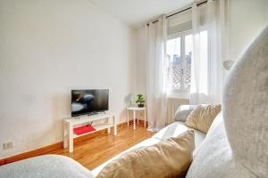 ein Wohnzimmer mit einem Sofa und einem TV in der Unterkunft Mesón Pamplona by Clabao in Pamplona