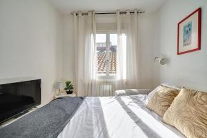 a white bedroom with a large bed and a window at Mesón Pamplona by Clabao in Pamplona