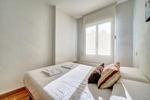 a white bed in a room with a window at Mesón Pamplona by Clabao in Pamplona