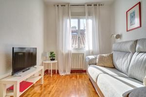 a living room with a couch and a tv at Mesón Pamplona by Clabao in Pamplona