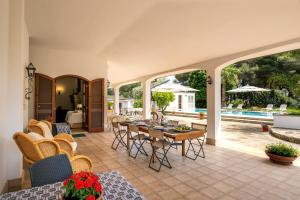 - un salon avec une table, des chaises et une piscine dans l'établissement Il Carretto, à Monteroni di Lecce