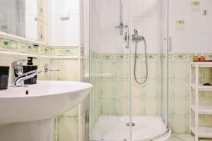 a bathroom with a sink and a shower at D&A Apartments Szewska in Krakow