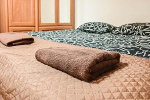 a bed with two brown pillows on top of it at D&A Apartments Szewska in Krakow