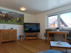 uma sala de estar com uma televisão de ecrã plano na parede em Berglust em Obermaiselstein