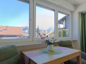 um quarto com uma mesa com um vaso de flores em Berglust em Obermaiselstein