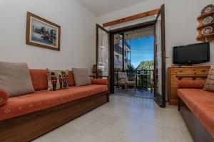 a living room with a couch and a flat screen tv at Kalifteri Beach House in Afissos