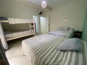 een slaapkamer met 2 bedden en een stapelbed bij Casa em Maresias Completa in Maresias