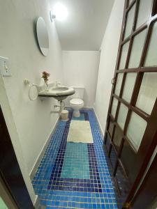 een badkamer met een toilet en een blauwe tegelvloer bij Casa em Maresias Completa in Maresias