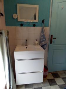 uma casa de banho com um lavatório, um espelho e uma porta em Aux Roses em Vrolle