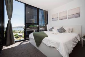 1 dormitorio con cama grande y ventana grande en Modern 2b2b Apt -2 king bed-2 parking-UC-Westfield en Belconnen