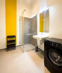 ein Badezimmer mit einer Waschmaschine und einem Waschbecken in der Unterkunft Exclusive Suite Museumsquartier in Wien