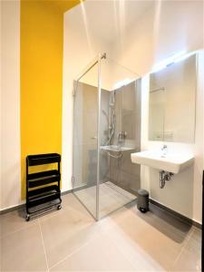 ein Bad mit einer Glasdusche und einem Waschbecken in der Unterkunft Exclusive Suite Museumsquartier in Wien