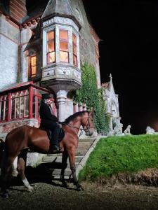 un hombre montando un caballo delante de una casa en West Holme Glamping, en Wareham