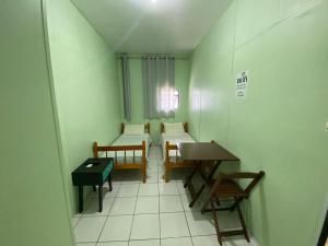 Pousada 355 في باسو فوندو: غرفة بسريرين وطاولة وكراسي