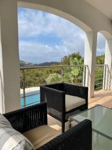 a balcony with a table and chairs and a pool at Villa vue mer et pinède in Bandol