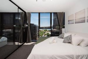 a bedroom with a white bed with a large window at Modern 2b2b Apt -2 king bed-2 parking-UC-Westfield in Belconnen