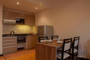 a kitchen with a table with chairs and a refrigerator at Departamentos - Belgrano 810 in San Martín de los Andes