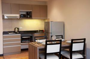 a kitchen with a table with chairs and a refrigerator at Departamentos - Belgrano 810 in San Martín de los Andes