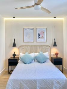 1 dormitorio con cama blanca y almohadas azules en AM II Segovia VUT en Segovia