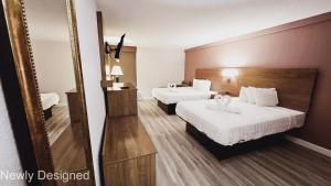 a hotel room with two beds and a mirror at SureStay Plus Hotel by Best Western Hopkinsville - Newly Renovated in Hopkinsville