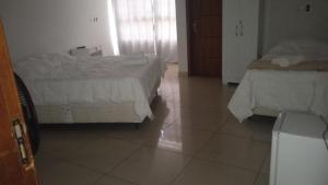 a bedroom with two beds and a tiled floor at Hotel Santorine Prime - Itabira in Itabira +31 photos