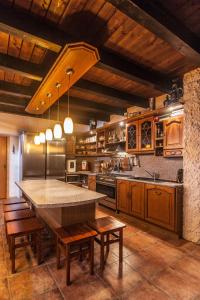 a large kitchen with a large table and wooden cabinets at Chalet Drevarska in Benecko
