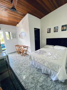 um quarto com uma cama e uma mesa em Maré Alta Suites - MARESIAS em Maresias