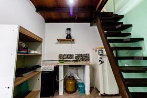 uma cozinha com um fogão e uma escada com uma chaleira. em Maré Alta Suites - MARESIAS em Maresias
