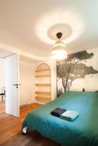 - une chambre dotée d'un lit vert et d'une fresque murale représentant les arbres dans l'établissement Sweet House Paris Disney, à Rosny-sous-Bois