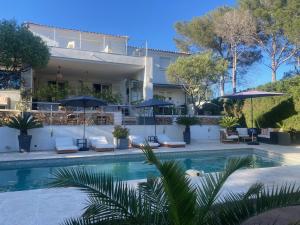 uma villa com piscina em frente a uma casa em "LES ALIZES" Côté PISCINE PROCHE BORD DE MER em Saint-Raphaël