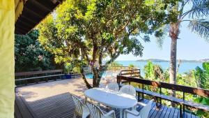 ボンビーニャスにあるA90 - Casa com piscina e linda vista - centro de Bombinhasの海の景色を望むデッキ(テーブル、椅子付)