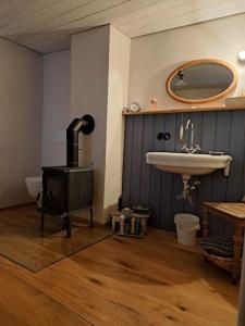 Un baño con estufa, lavabo y espejo. en Dinkelsbühler Altstadthäuschen, en Dinkelsbühl