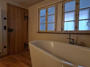 Una bañera blanca en un baño con ventana. en Dinkelsbühler Altstadthäuschen, en Dinkelsbühl