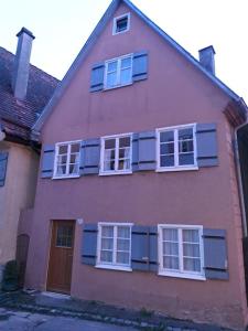 Una casa rosa con persianas azules. en Dinkelsbühler Altstadthäuschen, en Dinkelsbühl 11 fotos más