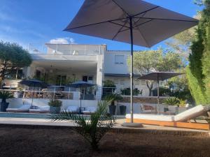 聖拉斐爾的住宿－"LES ALIZES" Côté PISCINE PROCHE BORD DE MER，一座带游泳池和遮阳伞的房子