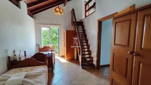 ボンビーニャスにあるA90 - Casa com piscina e linda vista - centro de Bombinhasの階段とベッドが備わる客室です。 +48枚の写真