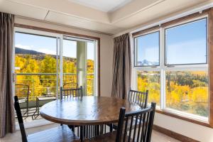 una sala da pranzo con tavolo, sedie e ampie finestre di The Peaks Resort and Spa a Telluride